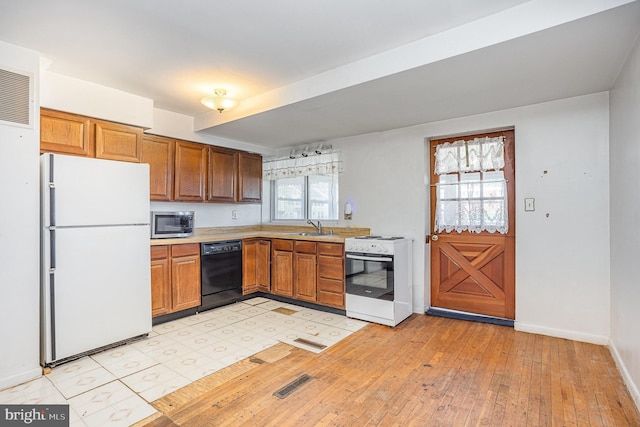 kitchen with white appliances, visible vents, light countertops, and a sink