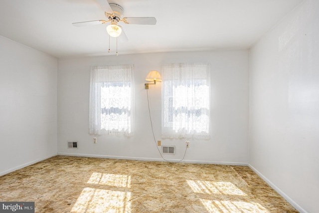 unfurnished room featuring a ceiling fan, visible vents, and a wealth of natural light