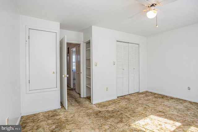 unfurnished bedroom with ceiling fan, a closet, baseboards, and carpet flooring