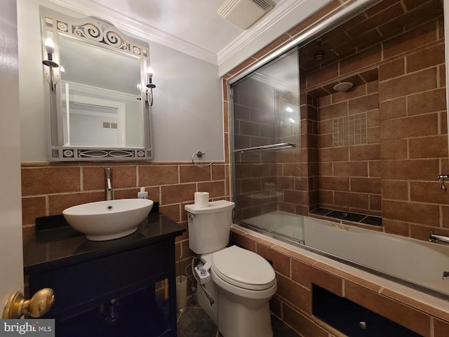 full bathroom featuring toilet, tiled shower / bath combo, vanity, tile walls, and ornamental molding