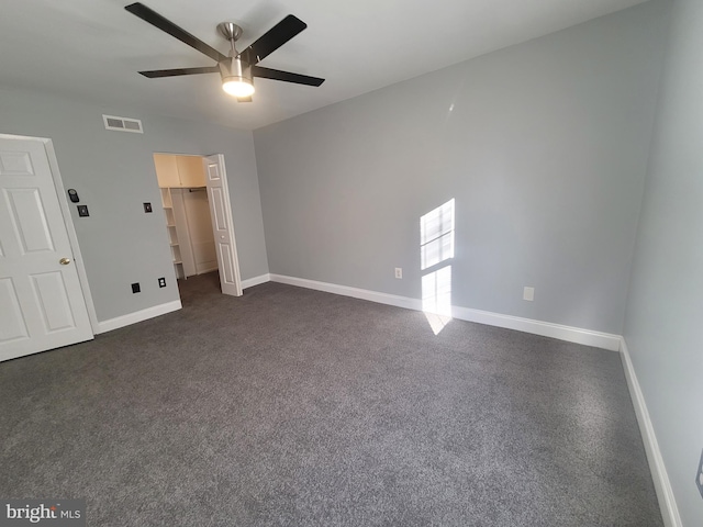 unfurnished bedroom featuring dark carpet, visible vents, ceiling fan, and baseboards