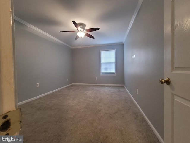 empty room with ornamental molding, carpet flooring, a ceiling fan, and baseboards