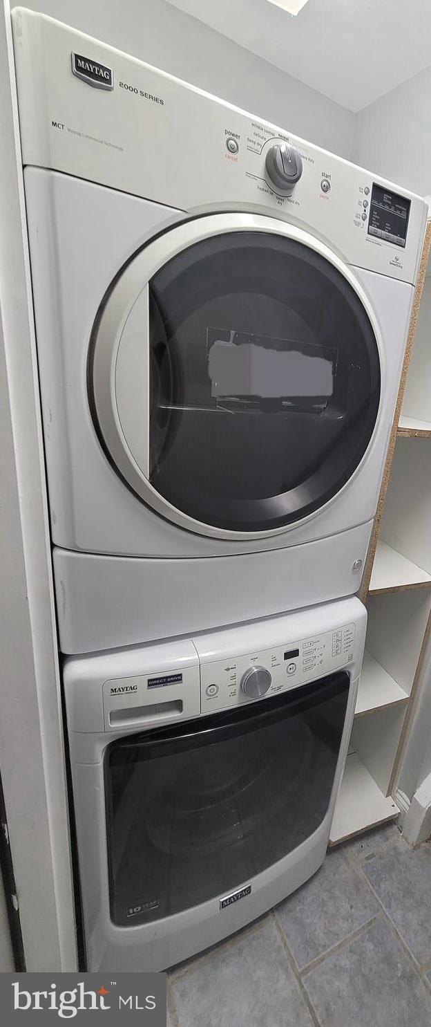 washroom with laundry area and stacked washer / dryer