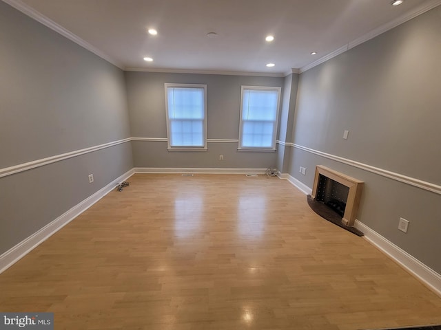 unfurnished living room with crown molding, light wood-type flooring, a fireplace, and baseboards