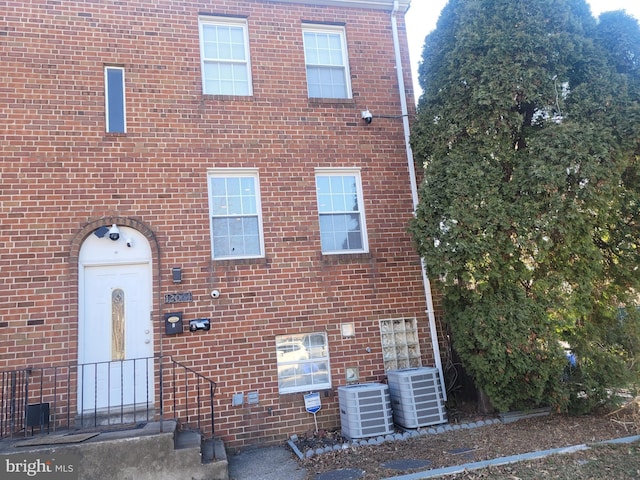 view of front of home with central AC unit and brick siding