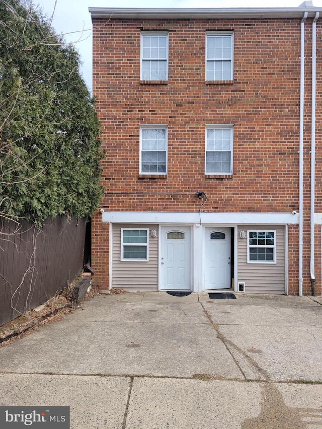 view of front facade featuring fence and brick siding