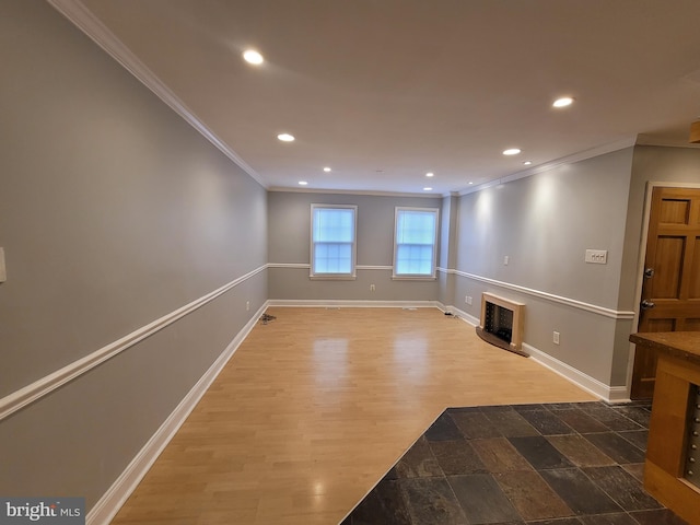 unfurnished living room featuring baseboards, ornamental molding, wood finished floors, a fireplace, and recessed lighting