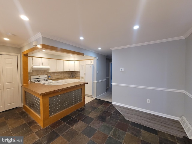 kitchen with stone tile floors, white appliances, visible vents, baseboards, and backsplash