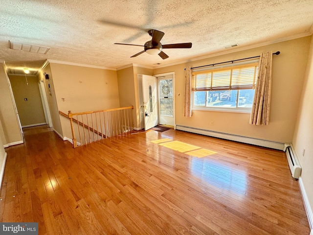 unfurnished room with attic access, a baseboard radiator, wood-type flooring, and visible vents