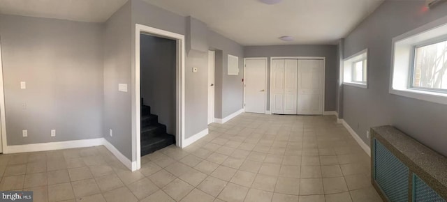 corridor featuring stairway, visible vents, baseboards, and light tile patterned flooring