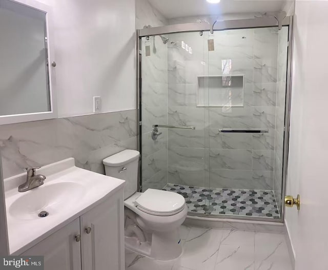 full bathroom featuring marble finish floor, toilet, vanity, and a marble finish shower