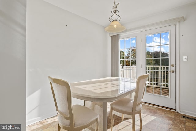 dining area with stone finish floor, baseboards, and visible vents