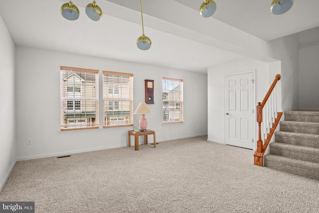 unfurnished room featuring carpet floors, baseboards, stairs, and visible vents