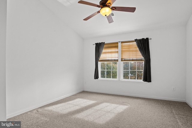 spare room with carpet, lofted ceiling, visible vents, ceiling fan, and baseboards