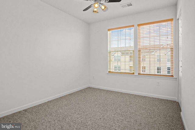 carpeted spare room with ceiling fan, plenty of natural light, visible vents, and baseboards