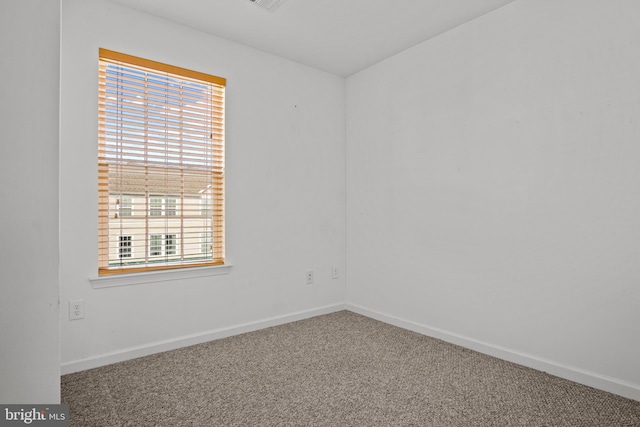 empty room featuring carpet floors and baseboards