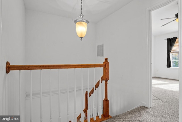 staircase featuring baseboards, carpet floors, visible vents, and a ceiling fan