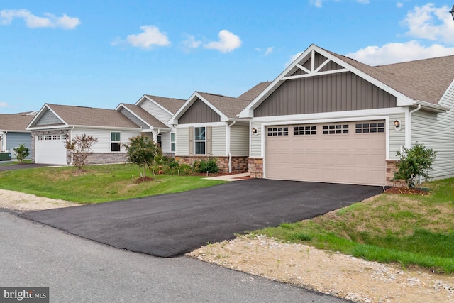 321 Windflower Dr Unit 9, Millsboro, DE 19966 - view of front of house with aphalt driveway, a shingled roof, board and batten siding, a front yard, and a garage