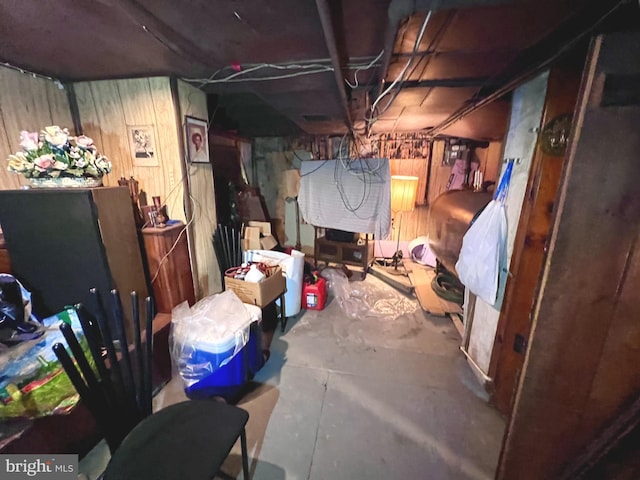 unfinished basement featuring wooden walls