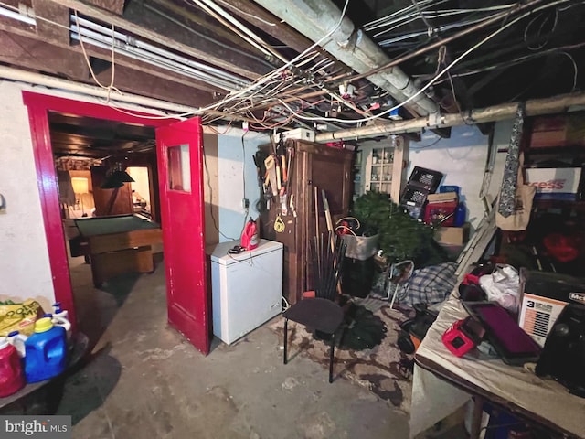 unfinished basement with fridge