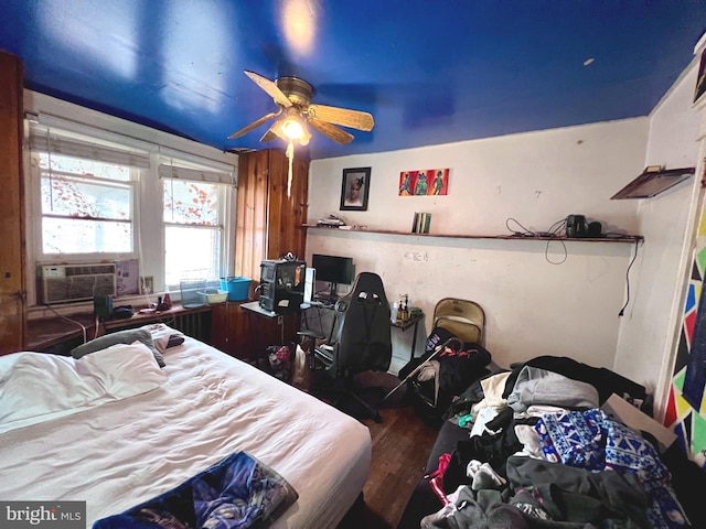 bedroom with cooling unit and wood finished floors