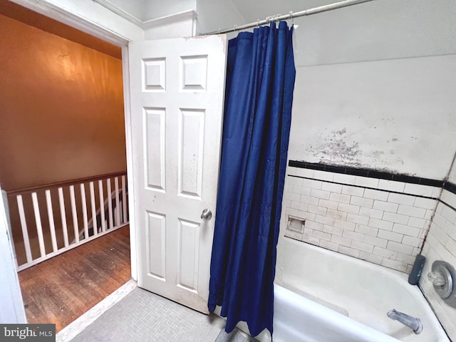 full bath featuring shower / bath combo with shower curtain and wood finished floors