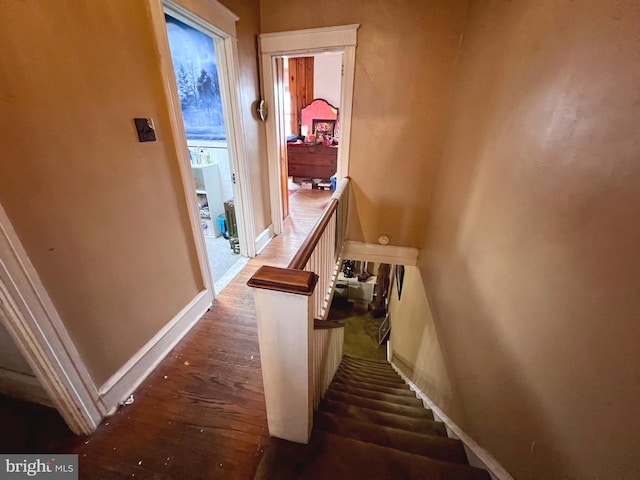 stairway with baseboards and wood finished floors