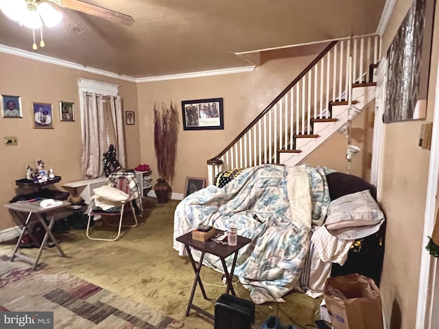 living area featuring baseboards, ceiling fan, stairway, and crown molding