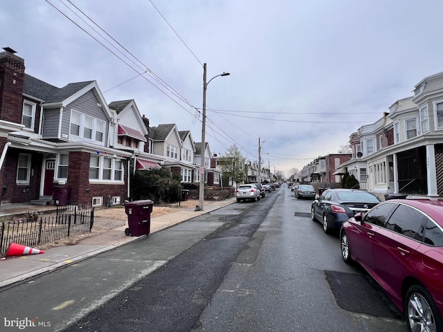 view of street with sidewalks, street lighting, a residential view, and curbs