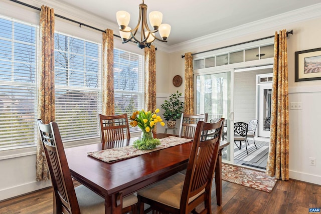 dining area featuring dark wood-type flooring, crown molding, baseboards, and an inviting chandelier