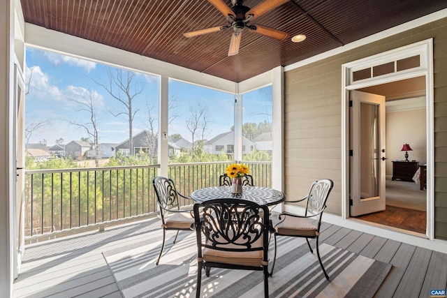 sunroom with a residential view, wood ceiling, and ceiling fan