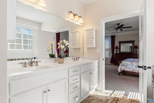 full bath with ensuite bathroom, double vanity, a sink, and a ceiling fan