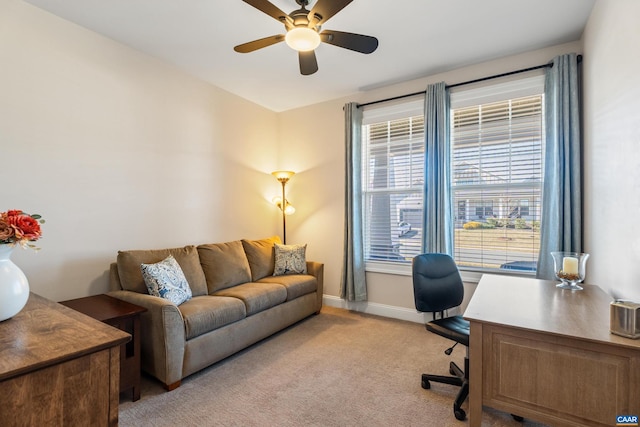 home office featuring light colored carpet, ceiling fan, and baseboards