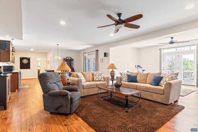 living room featuring baseboards, recessed lighting, a ceiling fan, and light wood-style floors