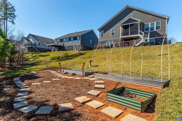 exterior space with a vegetable garden, a sunroom, and a lawn