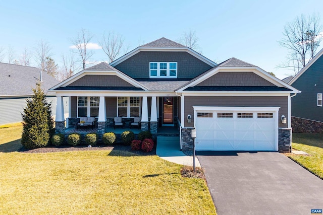 craftsman-style home featuring driveway, a porch, a front lawn, and an attached garage