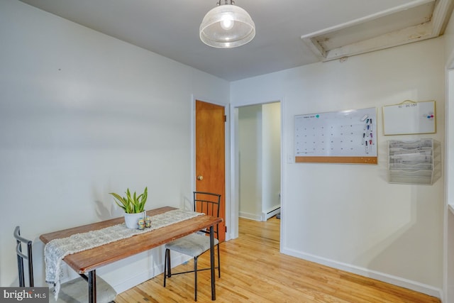 hall with light wood-style floors, baseboards, and baseboard heating