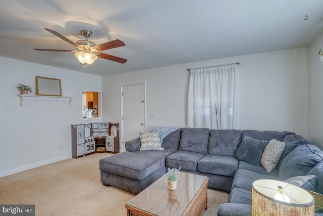 living room featuring baseboards, a ceiling fan, and light colored carpet