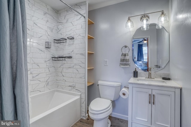 bathroom featuring toilet, wood finished floors, vanity, a ceiling fan, and shower / bath combo