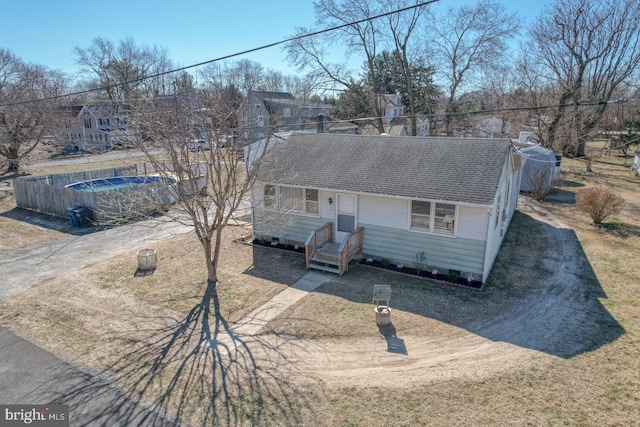 view of front facade featuring driveway and a shingled roof