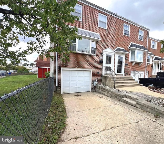 view of front of property featuring an attached garage, fence, concrete driveway, and brick siding