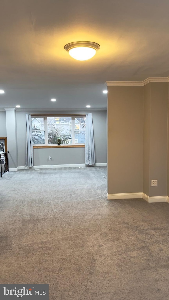 basement with carpet, ornamental molding, and baseboards