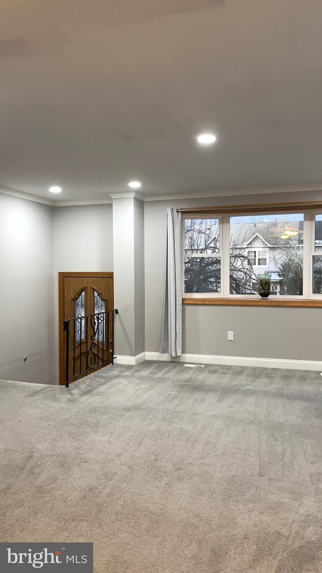 carpeted empty room with a healthy amount of sunlight, baseboards, ornamental molding, and recessed lighting