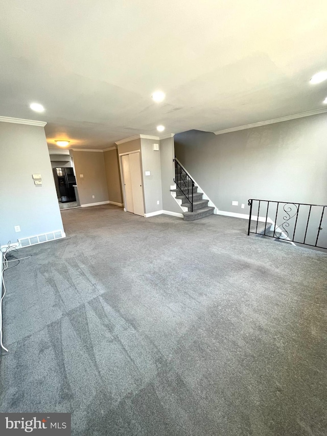 interior space featuring visible vents, baseboards, stairway, ornamental molding, and carpet