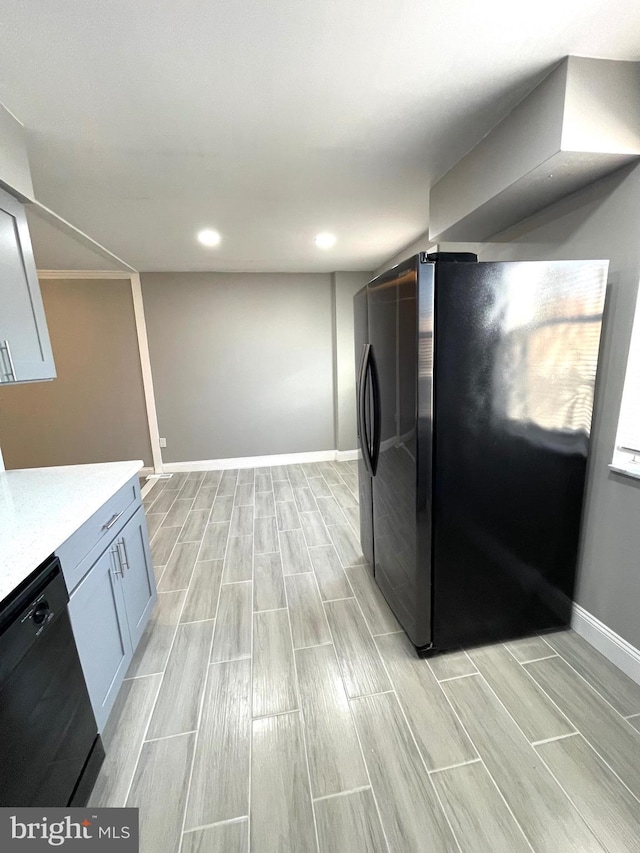 kitchen featuring baseboards, black appliances, recessed lighting, and wood tiled floor