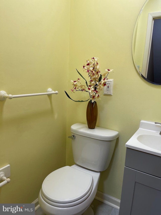 bathroom with vanity, toilet, and baseboards