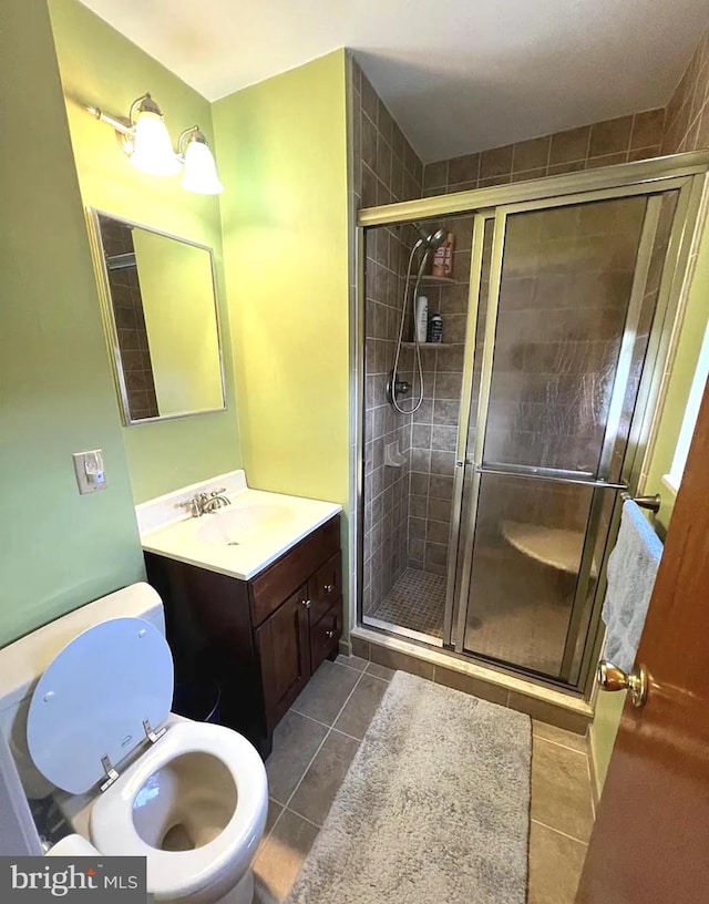 full bath featuring toilet, a shower stall, tile patterned flooring, and vanity