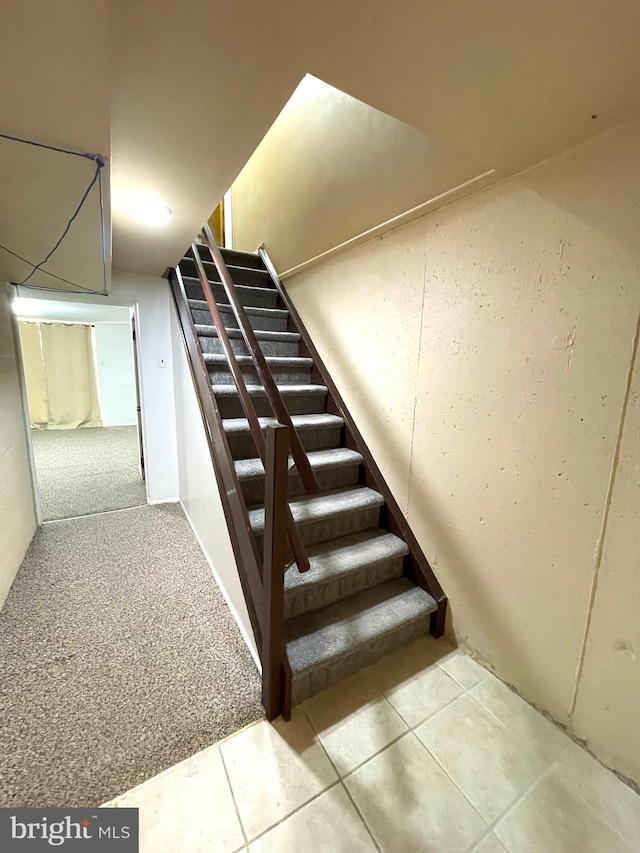 staircase with carpet and tile patterned floors