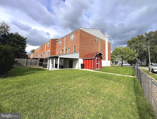 rear view of property featuring a lawn, a chimney, and fence