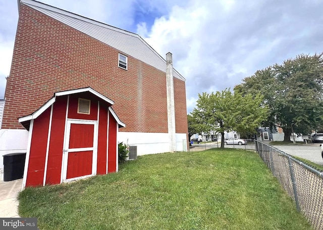 exterior space with central air condition unit, fence, and an outdoor structure